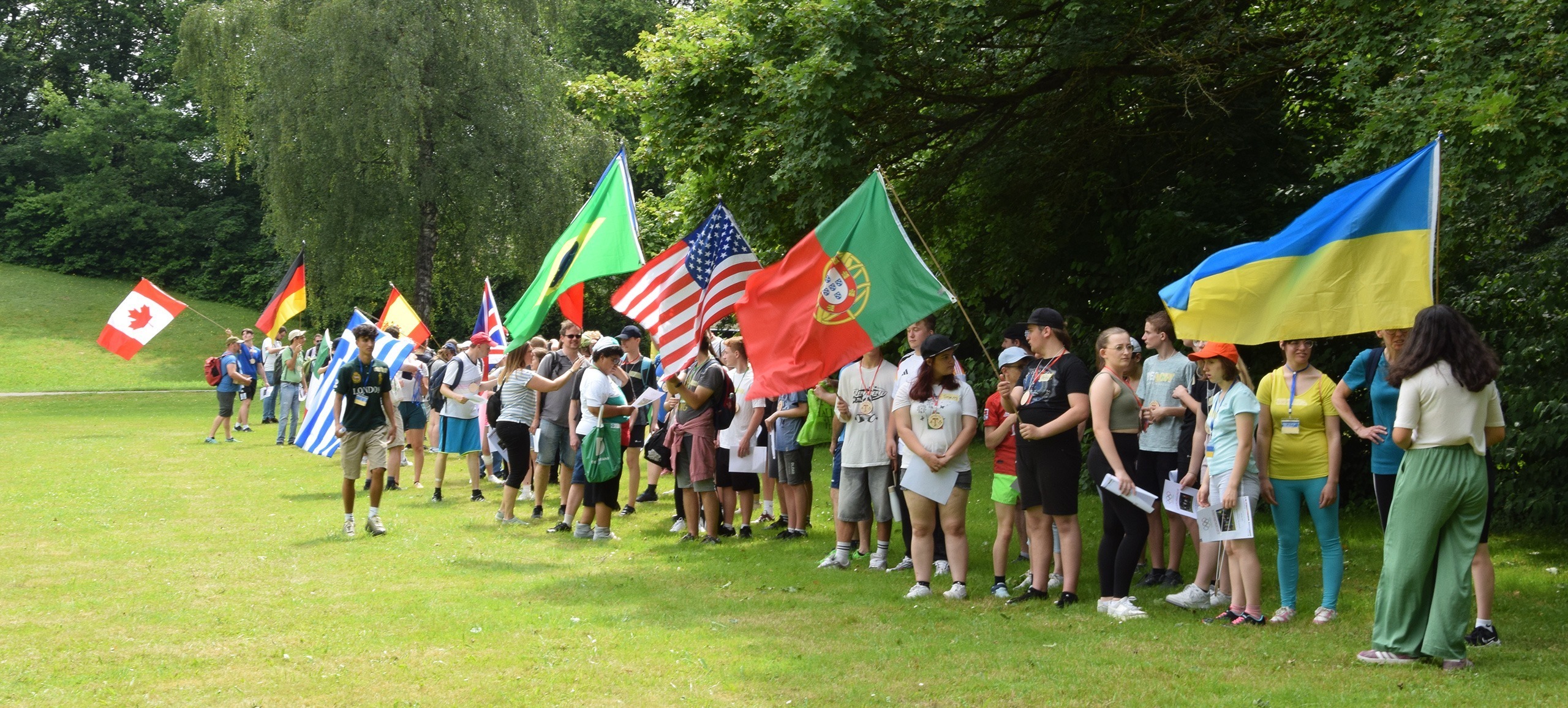 Schüler auf dem Rasen mit Flaggen ihrer Herkunftsländer